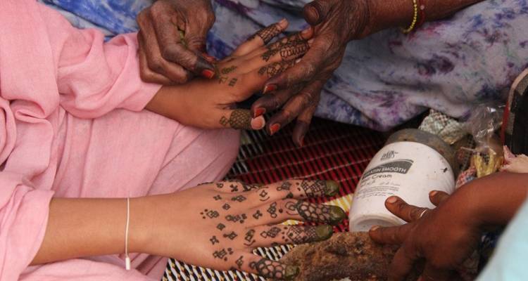 Traditional henna art being applied to someone's hands.