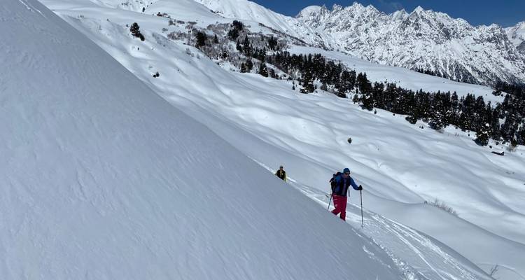 Un esquiador en una colina nevada empinada.