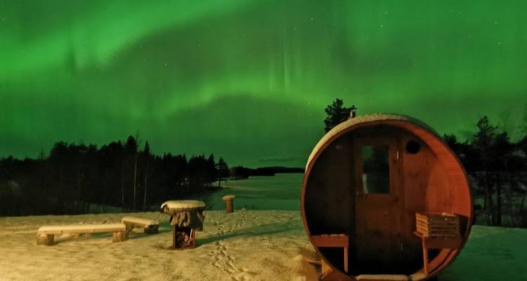 Aurores boréales au-dessus d'un paysage enneigé avec sauna