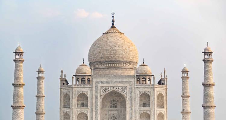 Marble dome and minarets of the Taj Mahal captured against a pale sky