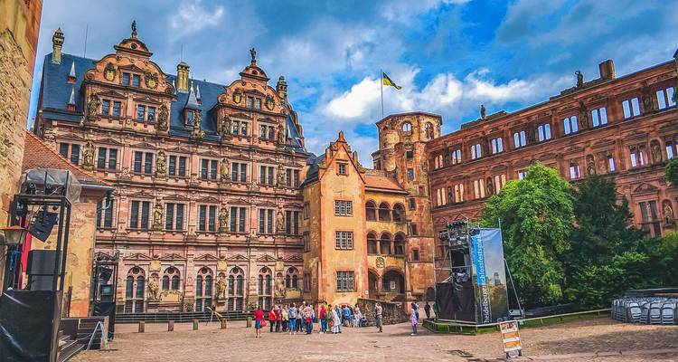 Tour group standing in the ornate courtyard of Heidelberg Castle surrounded by Renaissance façades.