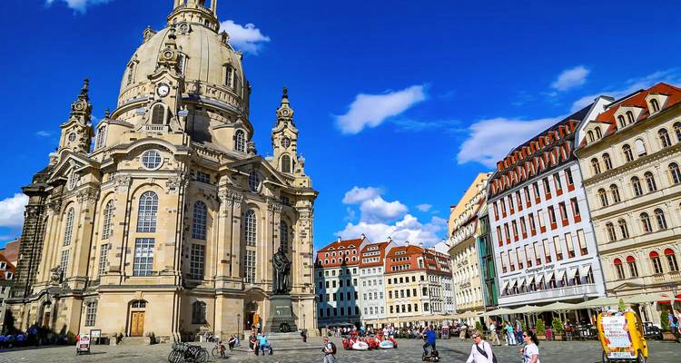 Frauenkirche and historic square in Dresden bustling with pedestrians and cyclists.