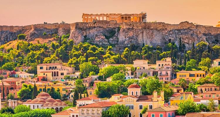 Bunte Gebäude und die Akropolis von Athen auf einem Hügel.