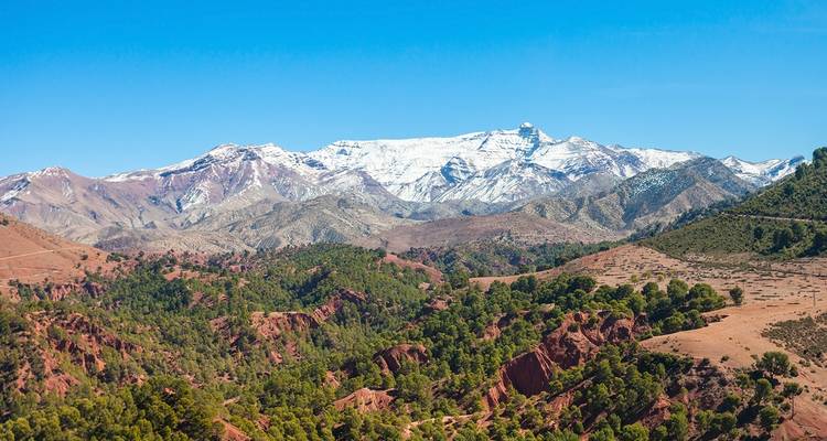 Paisaje montañoso escarpado con picos nevados bajo un cielo despejado.