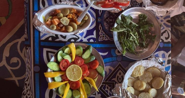 Repas égyptien traditionnel avec des salades de légumes colorées.