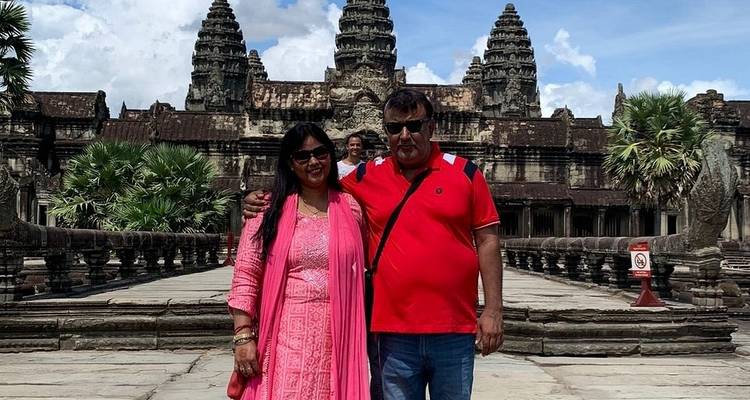 Couple sur un bateau devant un complexe de temples.