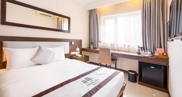 Habitación de hotel moderna con escritorio y ventana grande.