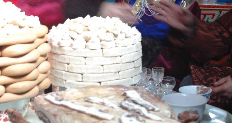 Unscharfes Bild, das eine kulturelle Veranstaltung mit traditionellem Kuchen zeigt.