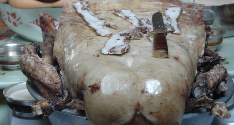 Teller mit traditionellem mongolischem Essen mit einem Messer.