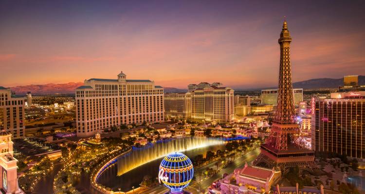 Panorama coucher de soleil de la bande de Las Vegas avec fontaines et skyline illuminé.