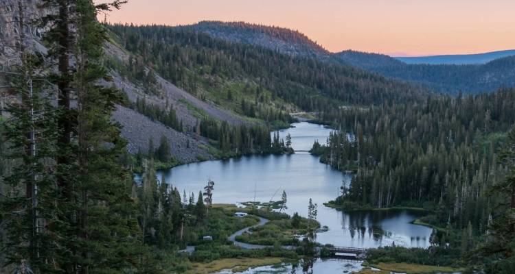 Twisting forested valley with interconnected alpine lakes at dusk near Mammoth Lakes.