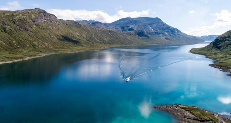 Bateau naviguant dans un fjord tranquille entouré de montagnes