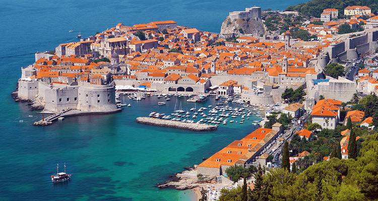 Vista aérea panorámica de los tejados de terracota de Dubrovnik rodeados por las aguas turquesas del Adriático