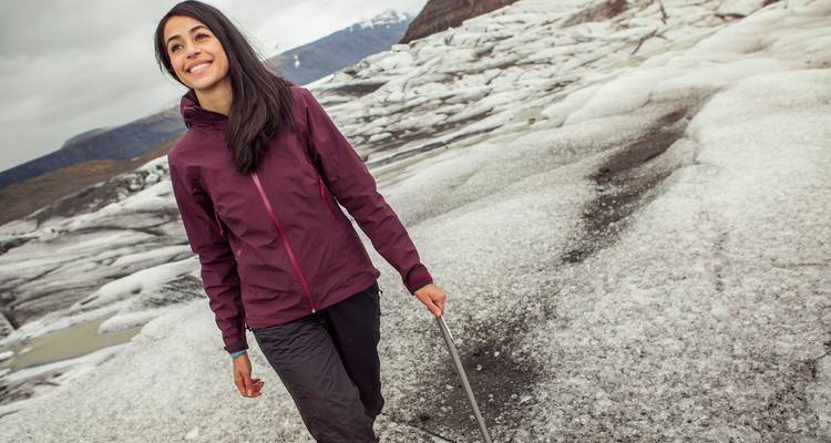 Femme en randonnée traversant la surface glacée du glacier Solheimajokull avec un bâton de trekking
