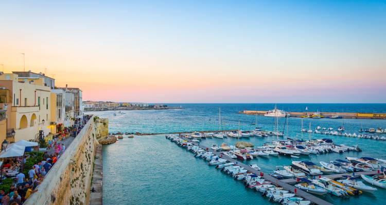 Atardecer colorido sobre la marina de Gálipoli llena de filas de barcos amarrados y restaurantes junto al mar