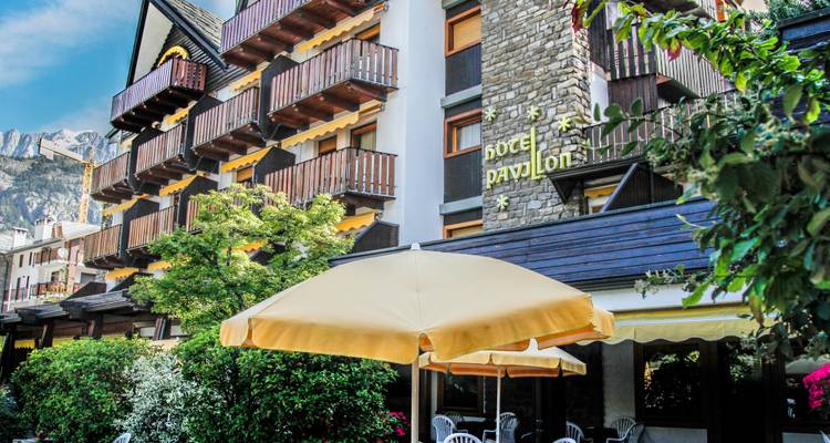 Hotel encantador con sombrillas amarillas en Chamonix, rodeado de montañas.