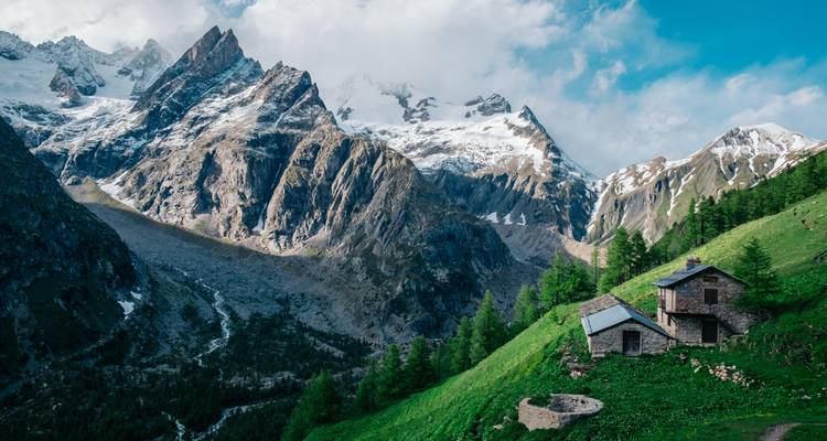 Paisaje alpino con montañas y una cabaña rústica, posiblemente cerca del Mont Blanc.