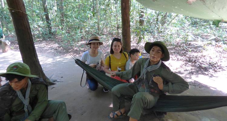 Gruppe von Menschen, die in einer bewaldeten Umgebung mit Hängematten interagieren.
