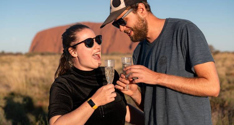 Couple profitant de boissons avec une grande formation rocheuse en arrière-plan.