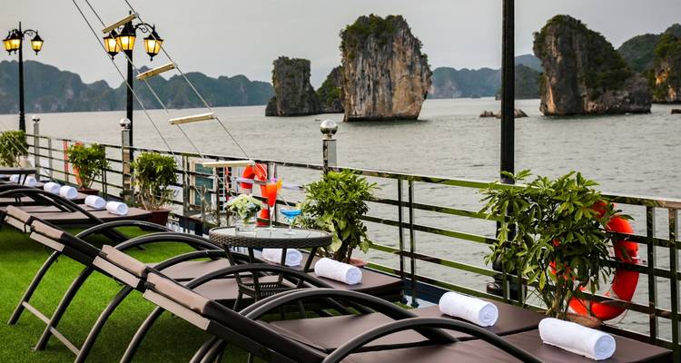 Terraza con tumbonas con vista a las islas de piedra caliza en la Bahía de Halong.