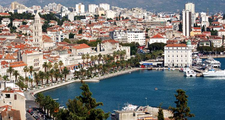 Aerial coastal view of Split’s historic Riva promenade lined with palm trees and the Adriatic Sea.