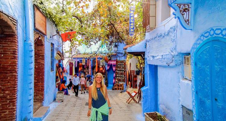 Una persona caminando por una calle pintada de azul brillante en Chefchaouen.