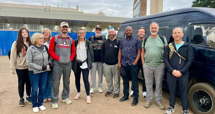 Group of travelers standing together for a group photo.