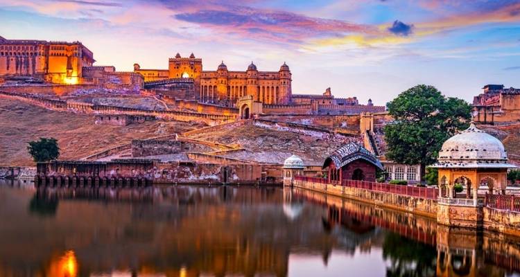 Amber Fort spiegelt sich bei Sonnenuntergang in einem See.