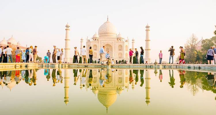 Touristen, die das Taj Mahal mit seiner Spiegelung im Wasser besuchen.