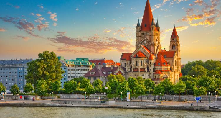 St. Francis of Assisi Church by the Danube River in Vienna, Austria during a colorful sunset.