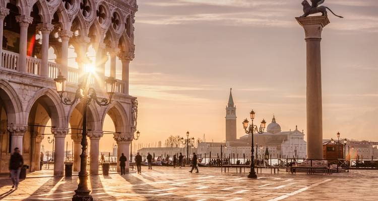 Piazza San Marco with the bell tower and column at sunrise.