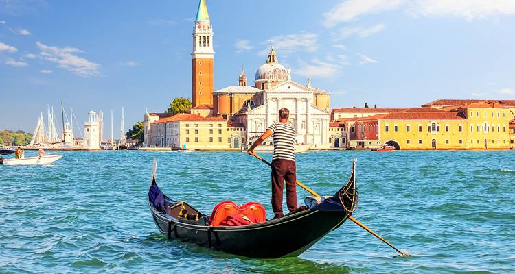 Gondolier dans une gondole sur un canal avec des bâtiments historiques.