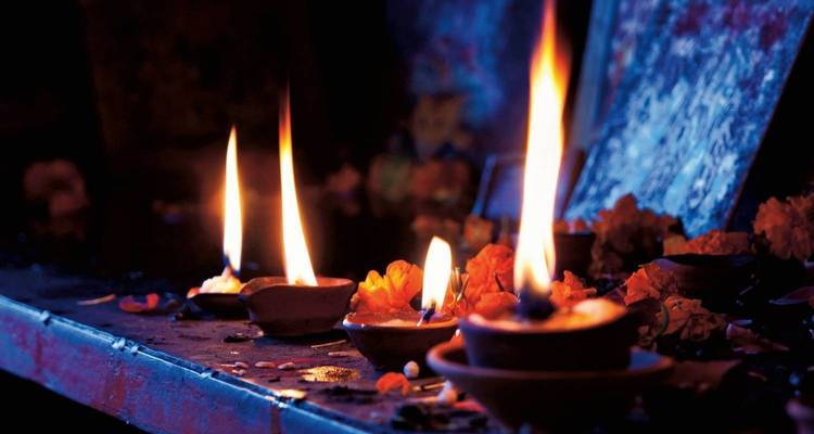 Vlammen in kleine containers tijdens een nachtelijke ceremonie.