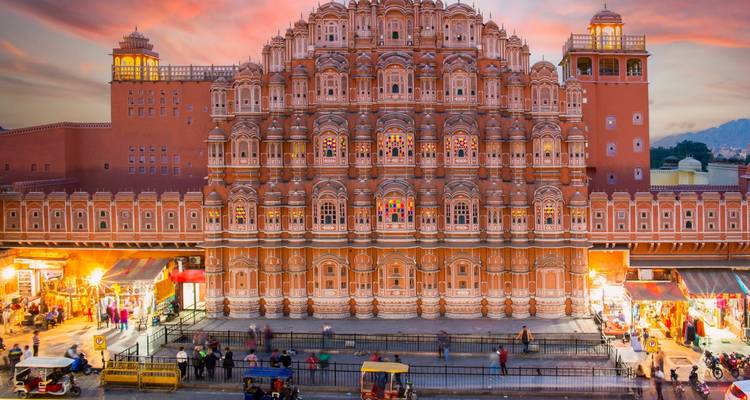 Een bruisende straatscène voor de Hawa Mahal tijdens zonsondergang.