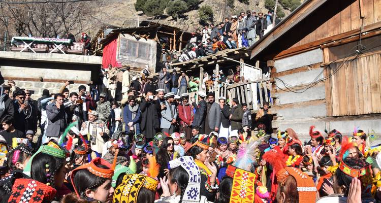 Große Menschenmenge bei einem Outdoor-Festival in traditioneller Kleidung.