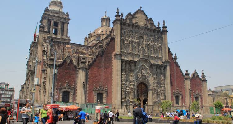 Historische kathedraal met sierlijke gevel en mensen eromheen.