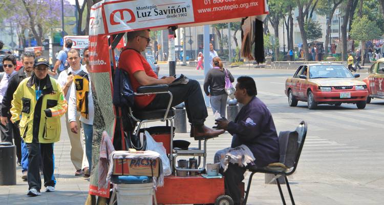 Drukke stedelijke scène met een schoenpoetsstand en verschillende mensen.