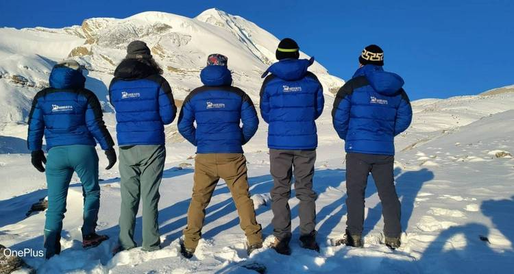 Gruppe von Menschen, die auf einen schneebedeckten Berg blicken