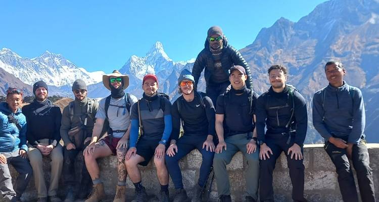 Gruppe von Wanderern, die vor bergiger Kulisse sitzen.