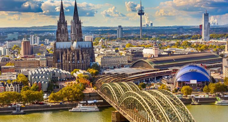 Aerial view of Cologne featuring Cologne Cathedral, Hohenzollern Bridge and the Rhine on a sunny day.
