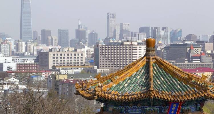 Azotea de un edificio tradicional chino con el horizonte de la ciudad al fondo.