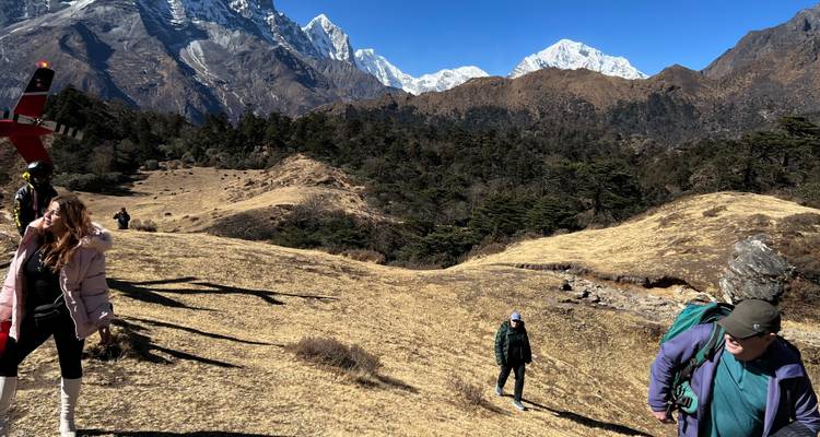 Wandelscène met bergen en mensen die rugzakken dragen.