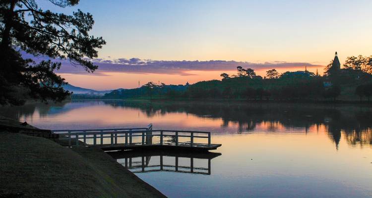 Calm lake with a dock at sunset