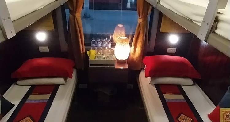 Treincoupe interieur met stapelbedden en gedimde verlichting.