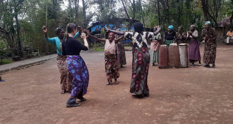 Gruppe von Frauen, die im Freien in traditioneller Kleidung tanzen.