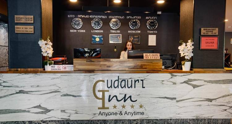 Receptieruimte van Gudauri Inn met wereldklokken en decoratie.