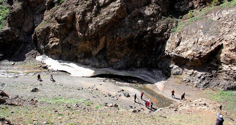 Een groep die een rotsachtig ijsveld verkent onder het zonlicht.
