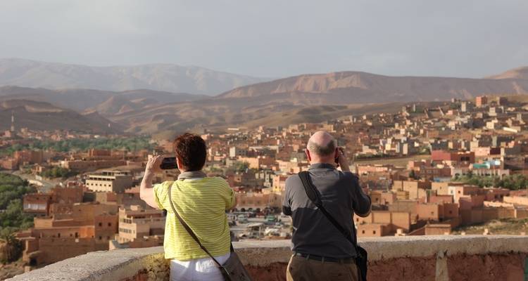 Zwei Personen fotografieren eine Stadtlandschaft von einem Aussichtspunkt aus.