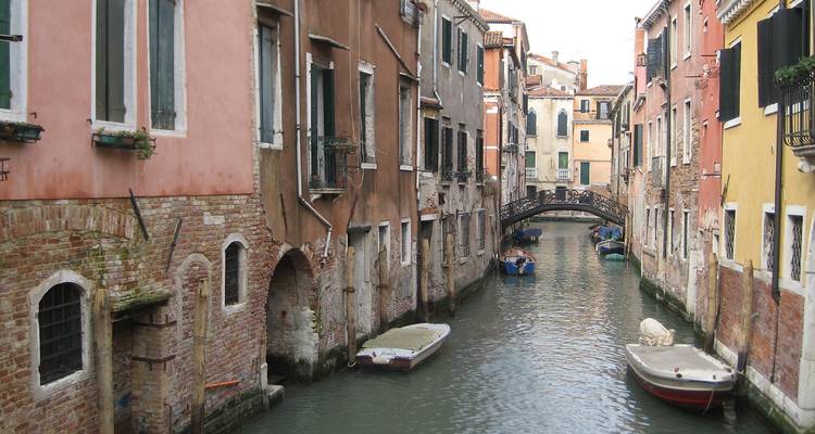 Enger Venezianischer Kanal, gesäumt von farbenfrohen alten Gebäuden und vertäuten Booten.
