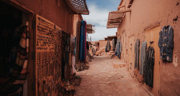 Enge Straße mit hängenden Textilien und Teppichen.